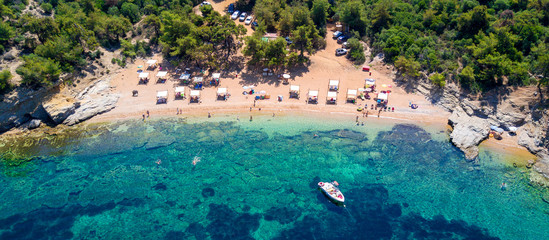 Naklejka na ściany i meble Aerial view of sandy beach with sunbathing tourists and clear turquoise sea