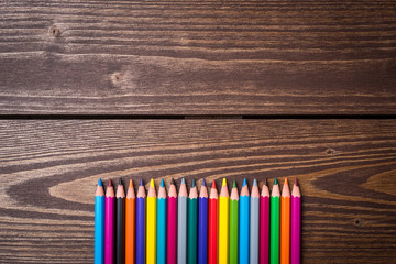 Colorful pencils on an old wooden table