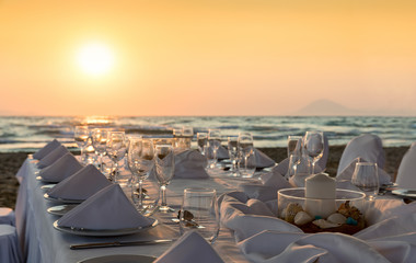 Elegantes Tischgedeck am Strand bei Sonnenuntergang