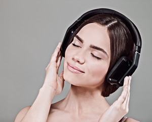 Fototapeta premium Music. Beauty young adult woman listen music with headset