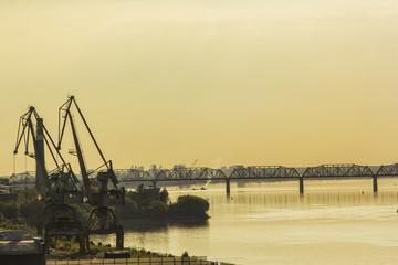Obraz premium Port cranes against the background of the sunset sun in the evening