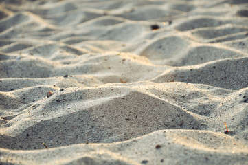 Texture of waves of beige gray sand. Selective focus.