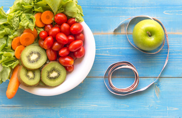 Healthy lifestyle for women diet with measuring tape, vegetable fresh, green apples blue on wooden.  Healthy Concept.