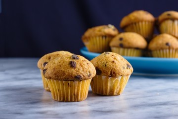 Three mini chocolate chips muffins on marble table. Close up and selective focus