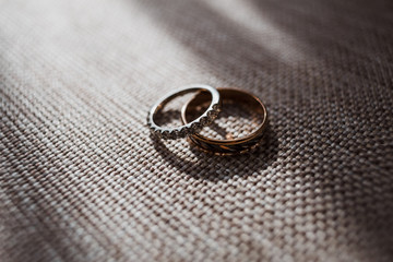 Obraz na płótnie Canvas Golden wedding rings with sparkling stones lie on the chair
