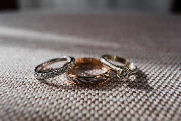 Golden wedding rings with sparkling stones lie on the chair