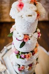 Gorgeous white wedding cake decorated with peonies and other flowers