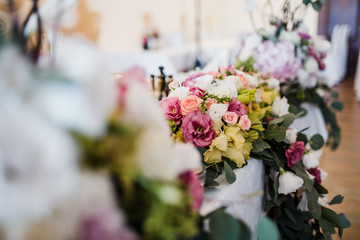 Garland of white and violet flowers hangs from the dinner table