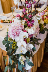 Garland of white and violet flowers hangs from the dinner table