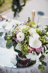 Bouquet of white and violet flowers stands on the table