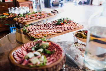 Wooden boards with sliced meat and greenery