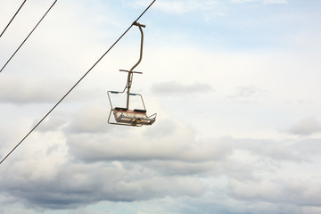 Empty chairlift with cloudy sky in the background