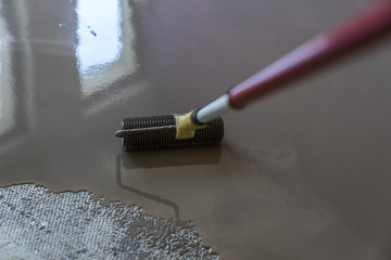Mirror smooth surface of the floor. Roller application. Floor co