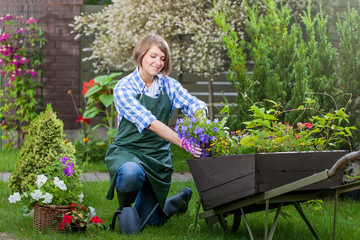 Young smiling woman florist working in the garden.