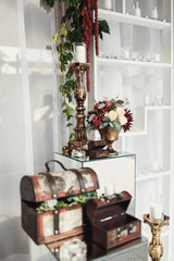 Little chests and bronze candleholders with red flowers