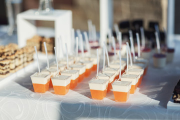 White and orange desserts in the glasses