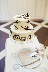 Tired wedding cake decorated with chocolate airplanes and suitcases