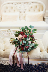 Rich wedding bouquet lies on the chair