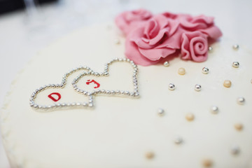 Wedding cake covered with silver balls and pink roses