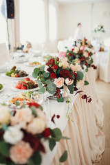 Bouquets of beige and red flowers stand on the table