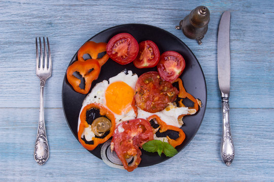 Healthy breakfast - fried eggs with tomatoes and pepper