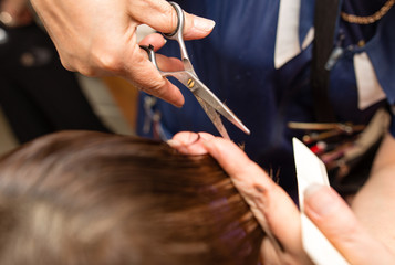 Obraz na płótnie Canvas Female haircut with scissors in the beauty salon