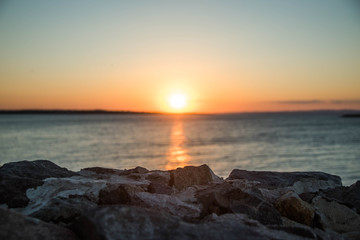 Fototapeta na wymiar Coastal stones on sunset background