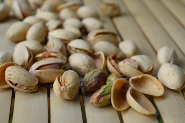 Pistachio nuts on bamboo table. Horizontal image.