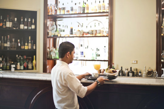 Waiter serving at the bar of the hotel