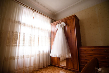 Wedding dress hanging in the room.