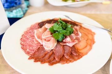 Cold cuts and sausages on a plate.