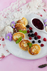 Cheesecake with berries for Breakfast, decorated with flowers on a pink background (close-up)