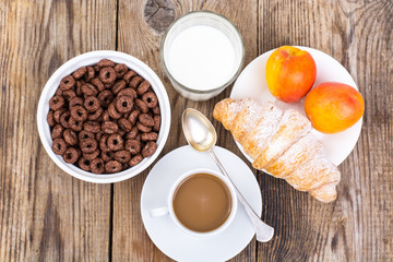 Chocolate cereal flakes, coffee, milk, croissant and fruit for b