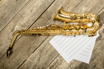 Beautiful golden saxophone on wooden background