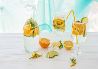 Cooling healthy drinks with fruit, lemonade, soda in glasses on a light background, fruit, ice slices. A wonderful cozy atmosphere of rest and enjoyment.
