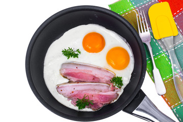 Fried eggs and bacon in frying pan on white background