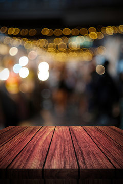 wooden table in front of abstract blurred background of lights