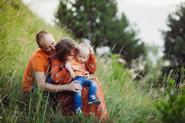 Family sits hugging on the lawn