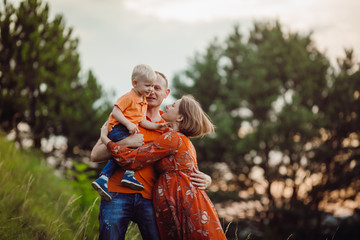 Parents have fun posing with his son on the lawn