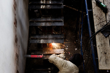 Men work welding Installation of steel stairs using steel i-beams.