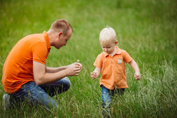Naklejka na ściany i meble Man and his son play on the lawn