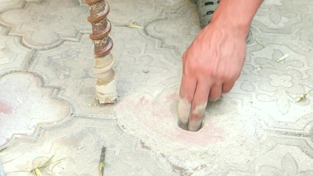 Drill During Operation. Closeup. Drilling of the wells. 4k. Slow motion. The man puts his fingers in the hole in the asphalt and touches his jackhammer. sex. Imitation of sex