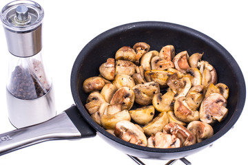 Halves of champignons fried in frying pan