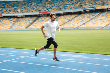 Fototapeta premium Side view of a young professional sprinter running