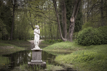 Shy woman sculpture in park.