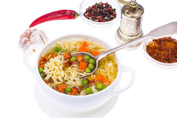 Noodle soup with green peas and carrots on white background