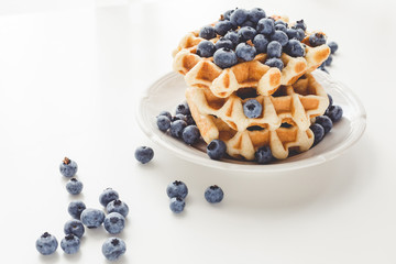 plate of tasty fresh stacked belgian waffles with blueberries