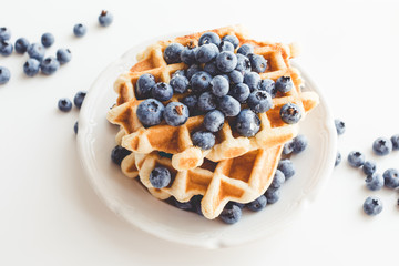 plate of tasty belgian waffles with blueberries