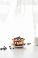 plate of freshly baked waffles with blueberries