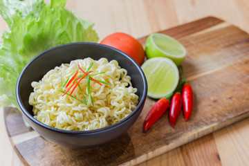 Instant noodles in white black on wood background, Asian meal on a table